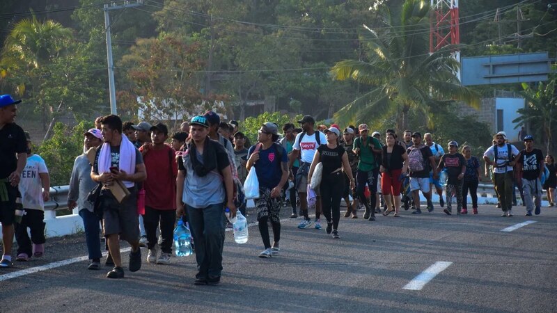 Migrantes caminan en caravana por carretera en busca de una mejor vida