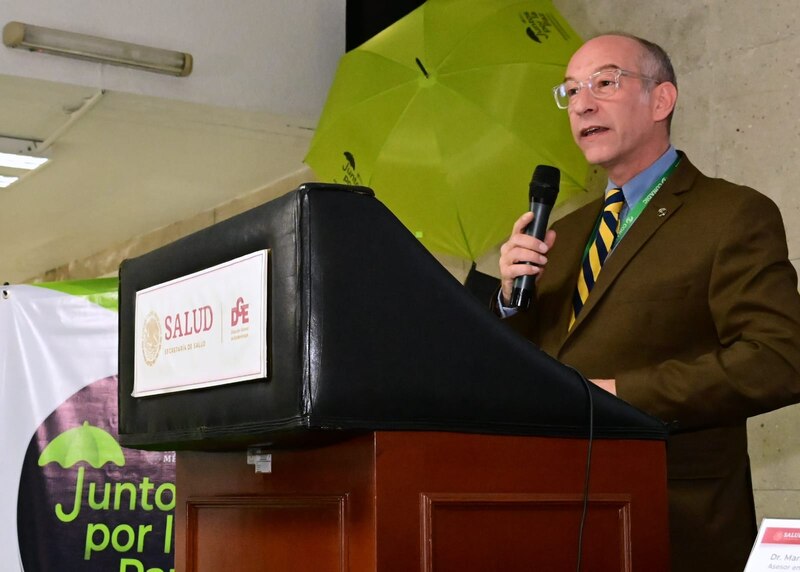El Dr. Armando Ahued, asesor en salud del gobierno de la Ciudad de México, habla en un podio durante un evento de salud pública.