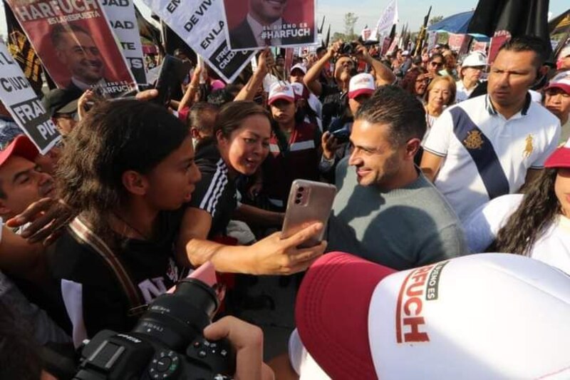 El candidato presidencial se toma una selfie con una mujer en un mitin político.