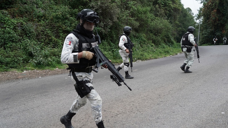 Policías mexicanos patrullan una calle en una zona rural