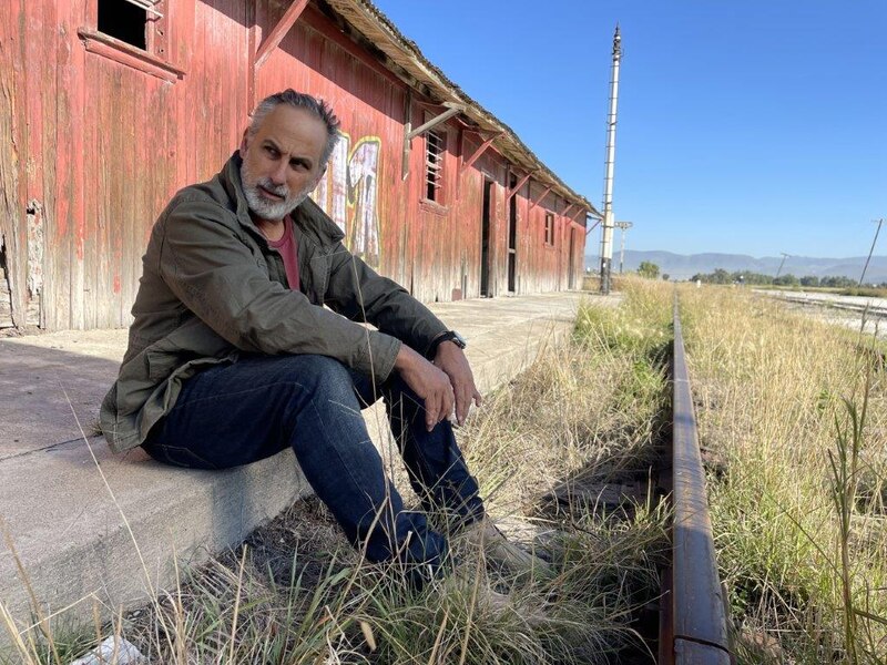 Un hombre sentado en las vías del tren