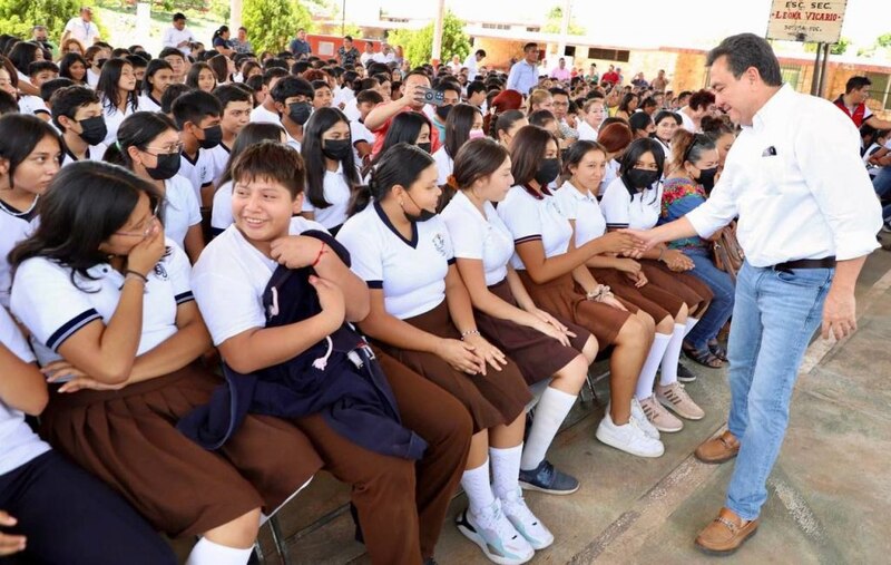 El presidente López Obrador saluda a estudiantes en una escuela secundaria