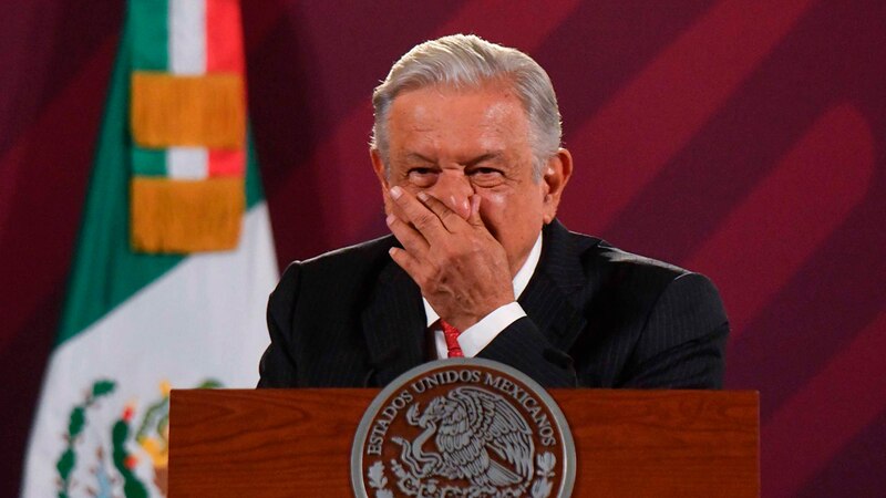 El presidente Andrés Manuel López Obrador tosiendo durante una conferencia de prensa.