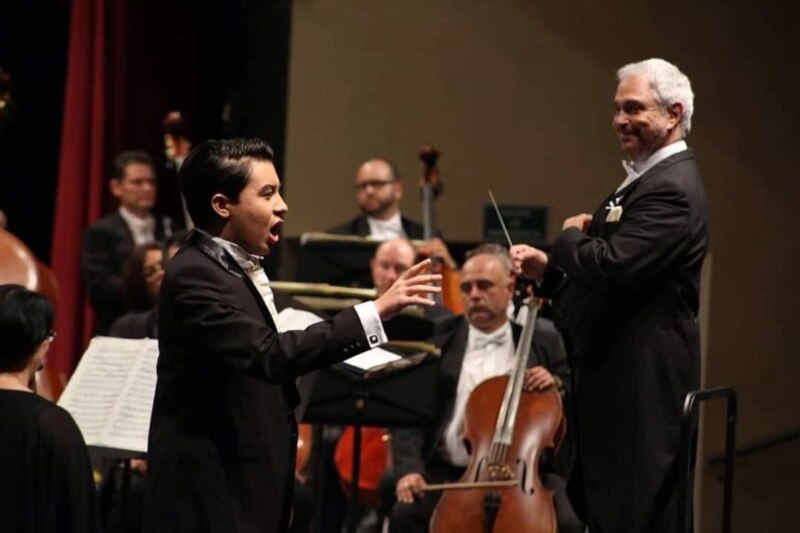 Un joven cantante de ópera actúa en un concierto.
