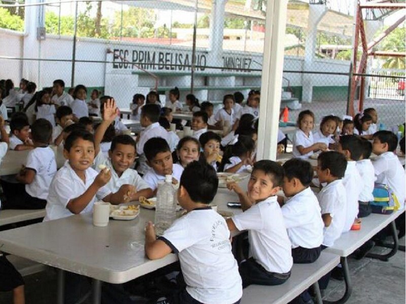 Niños de primaria comiendo en el comedor de la escuela