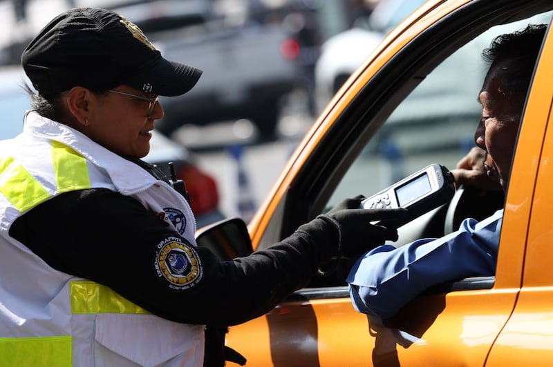 Una oficial de la SSC aplica el primer filtro de alcoholemia a conductores durante el banderazo de inicio del operativo Conduce Sin Alcohol para las fiestas decembrinas. El programa cumplió 23 años de servicio y ha prevenido al menos 260 mil accidentes relacionados al consumo de alcohol y conducción. Durante este arranque, un hombre excedió el límite permitido por lo que fue remitido junto con su vehículo.
