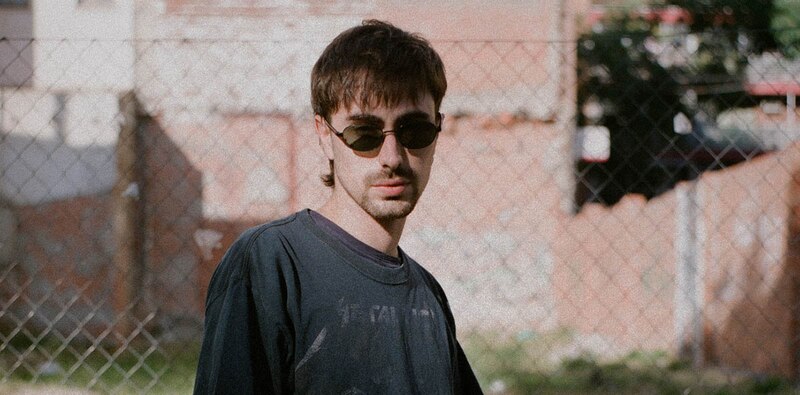 Un joven con gafas de sol y una camiseta negra