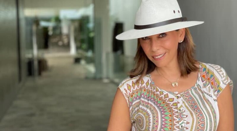 Mujer con sombrero de ala ancha y camisa estampada