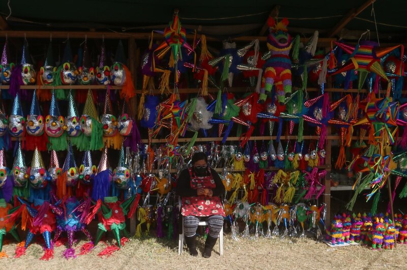 Una comerciante vende piñatas en la Romería Navideña de la Central de Abastos.