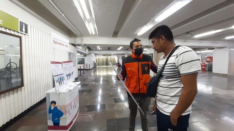 Un hombre sostiene un cartel en una estación de metro