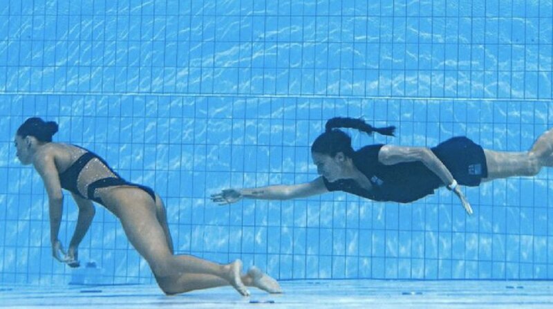 Dos nadadoras sincronizadas nadan bajo el agua