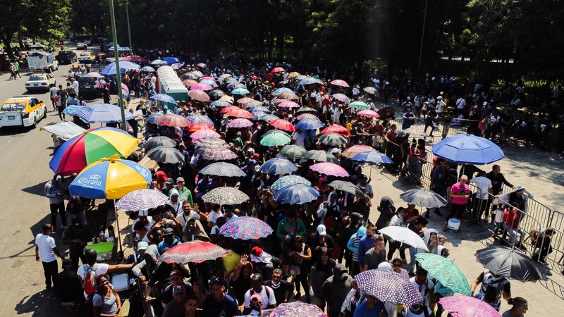 Multitud de personas esperando bajo los paraguas