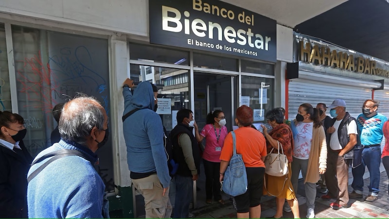 Larga fila de personas esperando para entrar al Banco del Bienestar