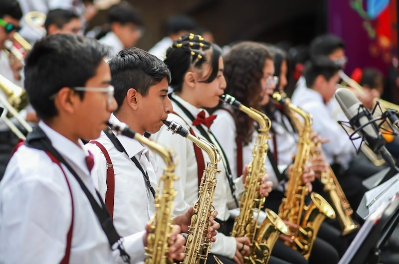 Estudiantes de secundaria tocando el saxofón en una banda