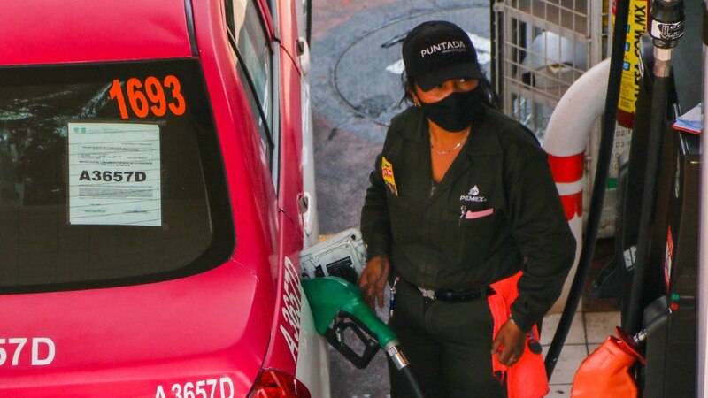 Mujer cargando gasolina en un automóvil rojo