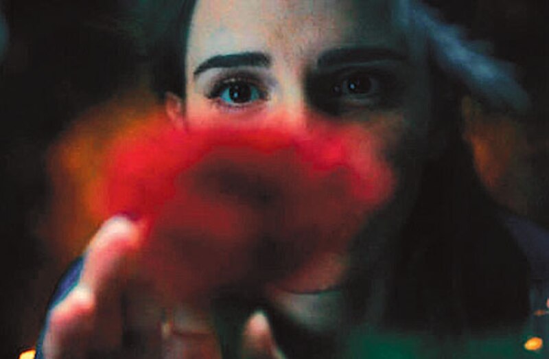 Mujer sosteniendo una flor roja