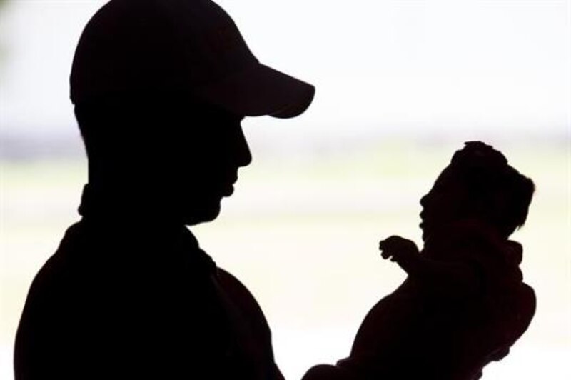 Un padre sostiene a su bebé en brazos