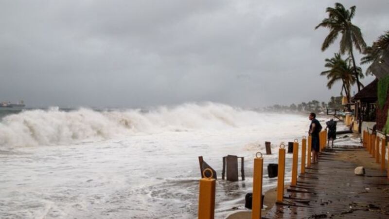 Un hombre observa las olas del mar durante una tormenta