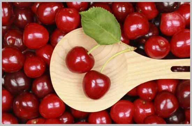 Cerezas en un tazón de madera