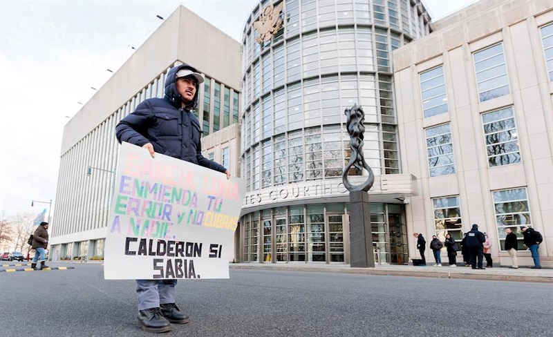 Un manifestante sostiene un cartel frente a un juzgado de Nueva York