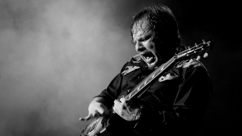 El rockero está tocando la guitarra en el escenario