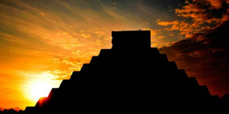 La imponente pirámide maya de Chichén Itzá se recorta contra el cielo del atardecer.