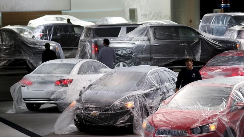Coches nuevos cubiertos con fundas en un concesionario