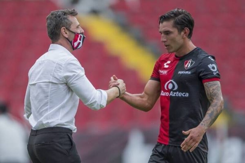 El entrenador de fútbol felicita a su jugador por el gol marcado