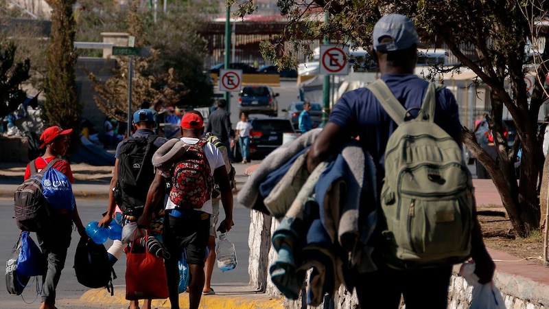 Migrantes venezolanos caminan por una calle en Tijuana, México