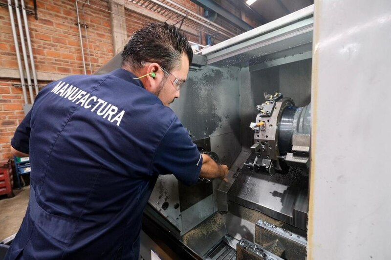 Operario trabajando en una máquina de torno CNC