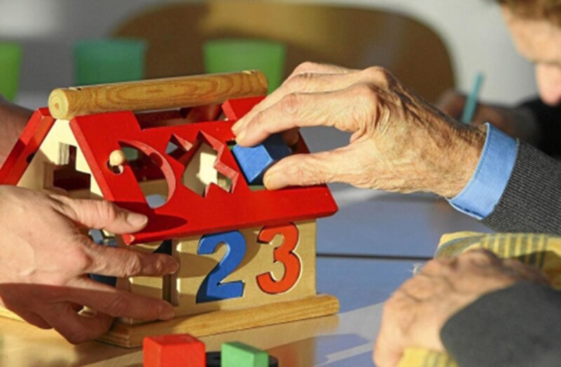 Adultos mayores jugando con un juguete de madera