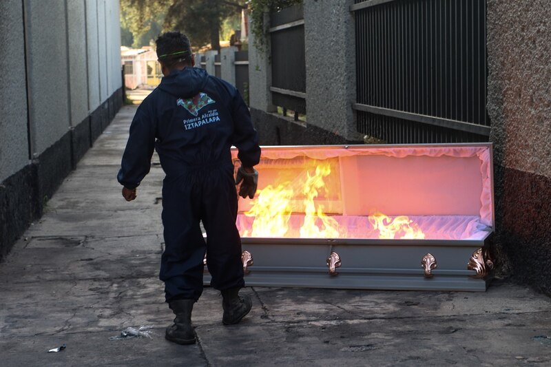 Un hombre quema un ataúd en la calle