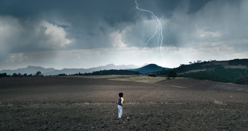 Niño mirando una tormenta eléctrica