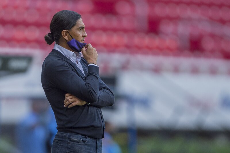 El entrenador de fútbol, Ricardo Gareca, observa el partido desde la banca.
