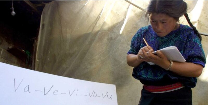 Mujer indígena escribiendo en un cuaderno