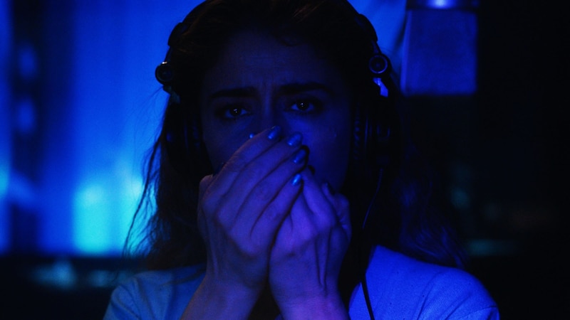 Mujer joven con auriculares en la oscuridad