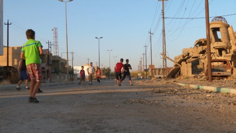 Niños jugando en las calles de una ciudad destruida