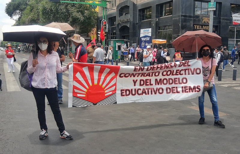 Dos mujeres sostienen una pancarta en una protesta.