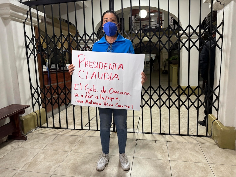 La saxofonista mexicana María Elena Ríos, sobreviviente de un intento de feminicidio, sostiene un cartel durante una protesta  en Oaxaca