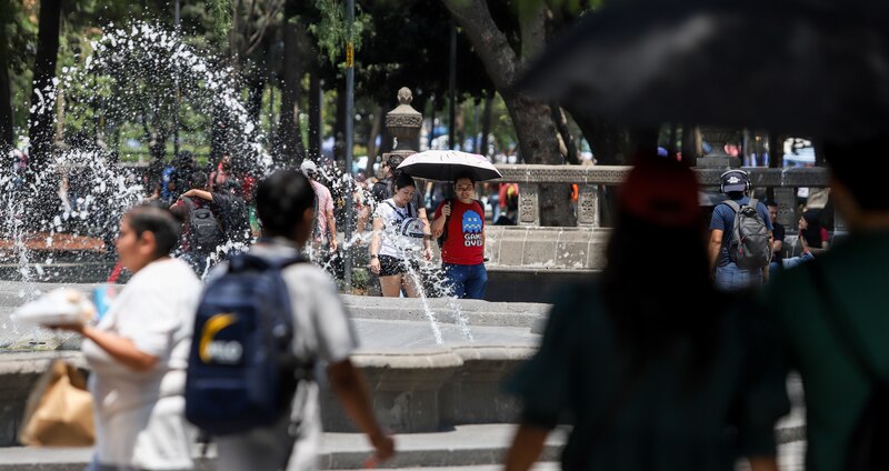 Una pareja se refresca en una fuente en la Ciudad de México