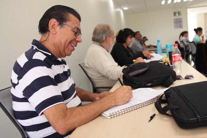 Un hombre mayor está escribiendo en una libreta.