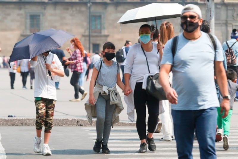 Familias usando cubrebocas en la calle