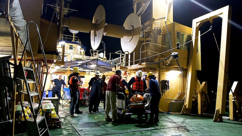 Científicos trabajando en la cubierta de un barco de investigación.