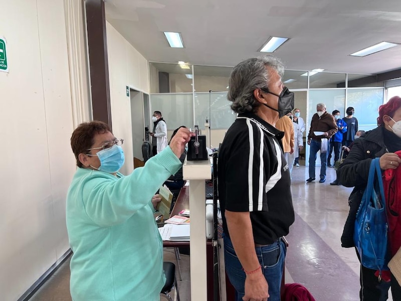 Personas esperando en fila para ser atendidas en una oficina.