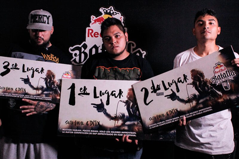 Tres MCs posando con sus trofeos en una batalla de rap.