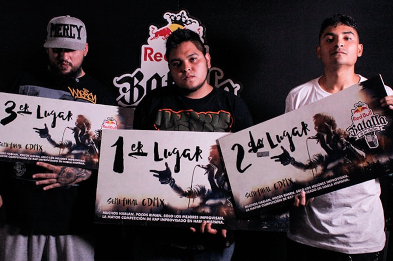 Tres MCs posando con sus trofeos en una batalla de rap.