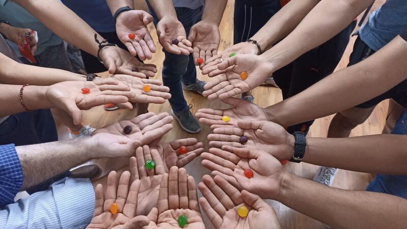 Manos sosteniendo dulces de colores
