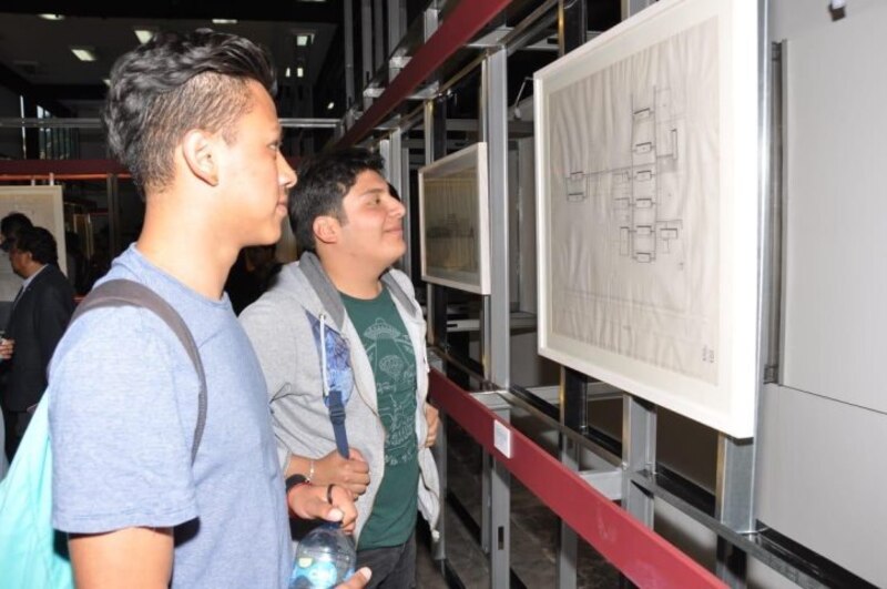 Estudiantes observan un plano en una exposición