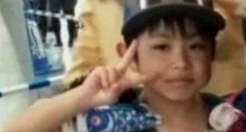 Niño asiático haciendo el signo de la paz