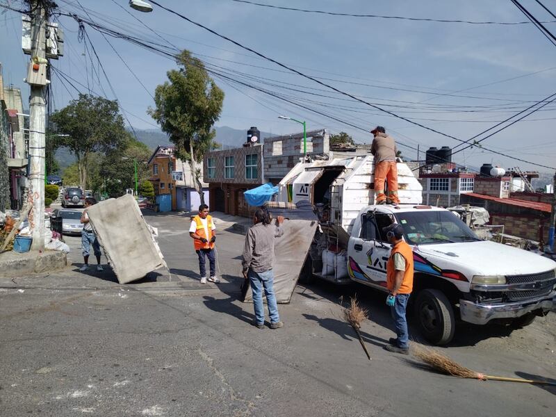 Trabajadores de limpia recogen basura en la calle